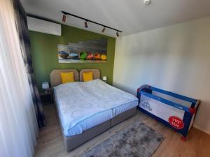 a small bedroom with a bed and a baby crib at Avenue Apartment in Prishtinë