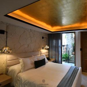una camera da letto con un grande letto bianco e un muro in pietra di Hotel Boutique Casa Laja a San Miguel de Allende