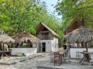 a resort with tables and chairs and a building at Popoyo Surfcamp in Popoyo