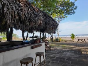 um bar com bancos e vista para a praia em Popoyo Surfcamp em Popoyo