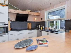 een keuken met een houten tafel met een boek erop bij 6 person holiday home in Glesborg in Bønnerup