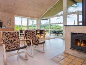 a living room with chairs and a fireplace at 6 person holiday home in Glesborg in Bønnerup