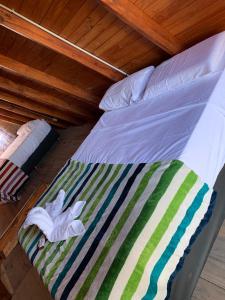 Una cama con una manta a rayas en una habitación en Cabañas alpinas del mirador en Bialet Massé