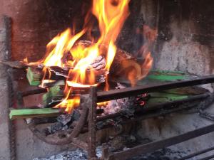 a piece of meat cooking on a grill with flames at Habitaciones en casa encantada para viajeros in Gualeguaychú