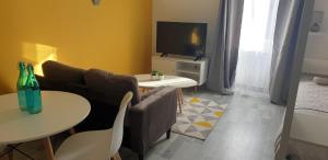 a living room with a couch and a table and a tv at Appartements entiers proche Aéroport - ZAC Chesnes - CNPE du Bugey Check-In 24h7J in Satolas-et-Bonce