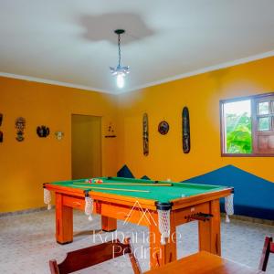 una mesa de ping pong en una habitación con paredes amarillas en Pousada Kabana de Pedra en Ibicoara