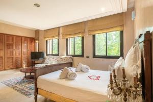 a bedroom with a bed and a couch at Villa près de golfs in Marrakech