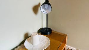 a table with a lamp and a roll of toilet paper on it at Big Private Room with Ensuite Bathroom in Town Center in Ipswich