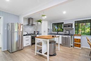 a kitchen with stainless steel appliances and a wooden table at Tamborine Palms Farmhouse in Tamborine