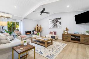a living room with a couch and a tv at Tamborine Palms Farmhouse in Tamborine