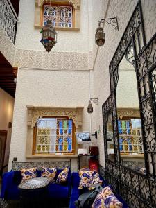 ein Wohnzimmer mit einem blauen Sofa und Fenstern in der Unterkunft Riad Najiba in Rabat