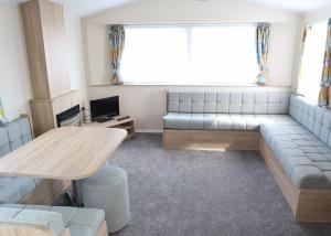 a living room with a couch and a table at Coastfields Holiday Village in Ingoldmells