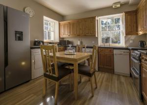 a kitchen with a wooden table and chairs in it at Gledfield Highland Estate in Culrain