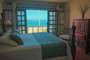 1 dormitorio con 1 cama y vistas al océano en Nanny Estate Cabarete Beachfront Condos Unit A2, en Cabarete