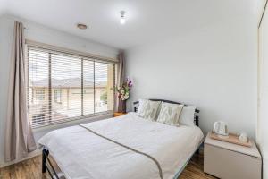 una camera con un letto bianco e una finestra di Melbourne Lovely Nest a Melbourne