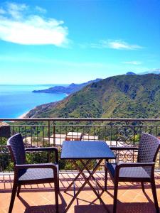 uma mesa e cadeiras numa varanda com vista para o oceano em Casa Francesco em Forza dʼAgro