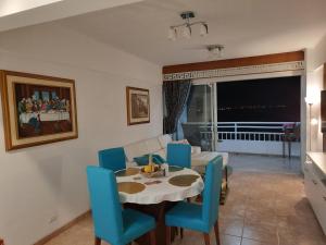 a dining room with a table and blue chairs at Carabelas de Colon con balcon grande y vista hermosa in Playas