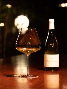 a bottle of wine sitting next to a wine glass at Hotel Wohnen in Hakuba