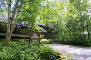 a sign in front of a building in the woods at Hotel Wohnen in Hakuba