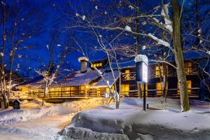 a house in the snow at night at Hotel Wohnen in Hakuba
