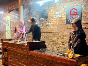 un grupo de personas de pie alrededor de una pared de ladrillo en Gading Chalet, en Kuala Terengganu 79 fotos más