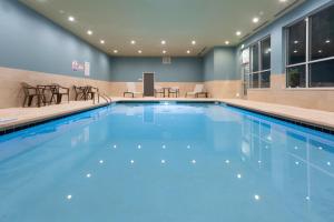 una piscina con acqua blu in una camera d'albergo di Holiday Inn Express & Suites - Firestone - Longmont , an IHG Hotel a Longmont