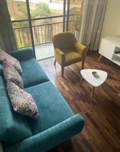 a living room with a blue couch and a chair at Departamento completo Surquillo/Miraflores in Lima