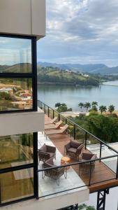 a balcony with chairs and a view of a lake at Vista do Lago Hotel in Capitólio