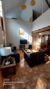 uma sala de estar com um sofá e uma televisão em Casa de Campo Villa Angélica Lunahuaná em Lunahuaná