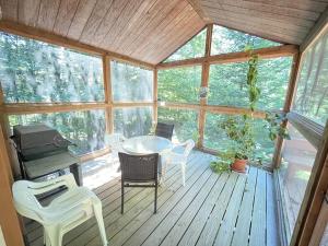 a screened in porch with a table and chairs at The Hidden Spruce Chalet in Peru