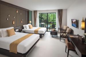 a hotel room with two beds and a desk at Centara Anda Dhevi Resort and Spa - SHA Plus in Ao Nang Beach