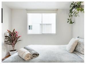 ein weißes Schlafzimmer mit einem Bett und einem Fenster in der Unterkunft Ny Napoles Condos WTC in Mexiko-Stadt