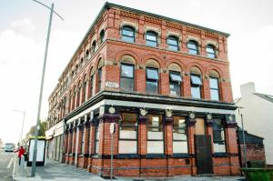 a red brick building on the corner of a street at Trivelles Liverpool in Liverpool +10 photos