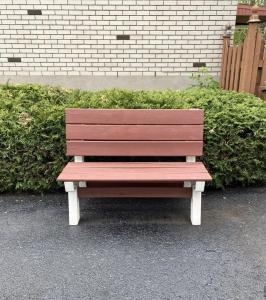 un banc en bois assis devant un mur de briques dans l'établissement Montreal - Laval Haven - Entire rental unit, à Laval