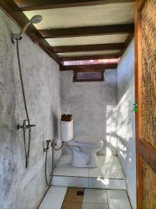 a bathroom with a toilet in a room at Bale Jukung in Tanjung