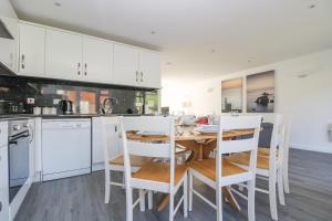a kitchen with a wooden table and white cabinets at Sea Breeze 17 Gannel in Truro