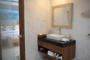 努沙杜瓦Kubu Garden Suites & Villas Nusa Dua的带水槽和镜子的浴室