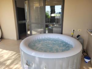 bañera grande en una habitación con ventana en Assaf's place - המקום של אסף, en Aẖihud
