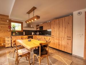 kuchnia z drewnianymi szafkami oraz drewnianym stołem i krzesłami w obiekcie Appartement Samoëns, 4 pièces, 7 personnes - FR-1-642-80 w mieście Samoëns
