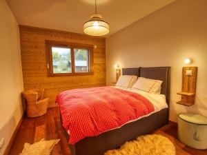 een slaapkamer met een bed met een rode deken en een raam bij Appartement Samoëns, 4 pièces, 7 personnes - FR-1-642-80 in Samoëns