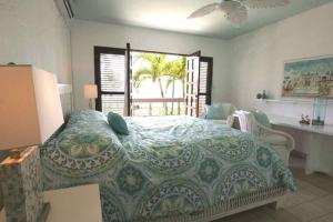 um quarto com uma cama, uma mesa e uma janela em Cabarete Beachfront Condos Nanny Estate A3 em Cabarete