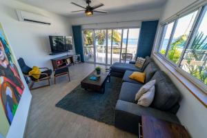 a living room with a sectional couch and a view of the ocean at WOW location Kite Beach Oceanfront Panoramic Views 2 DECKS 2 Bedrooms in Cabarete