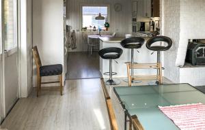 a living room with a table and chairs and a kitchen at 3 Bedroom Cozy Home In Svanesund in Svanesund