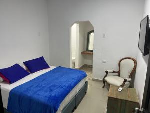 a bedroom with a bed and a chair and a mirror at Casa Torices Real 12 in Cartagena de Indias