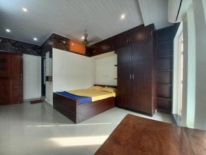 a bedroom with a bed and wooden cabinets at JEENA MOTEL in Kollam