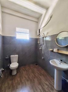 un bagno con un water, un lavandino e uno specchio di SunRay Rest - Beach View Homestay a Mirissa