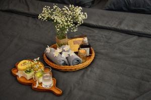 einen Korb mit Essen und eine Vase Blumen auf dem Bett in der Unterkunft Robin House in Hue