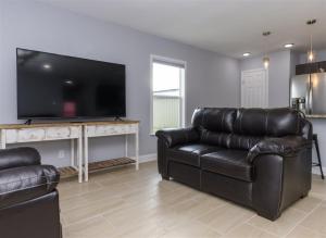 a living room with two leather couches and a flat screen tv at Mallard in Rockport