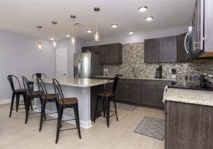 a kitchen with a large island with bar stools at Mallard in Rockport
