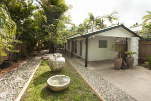 a house with two large vases in the yard at Drift Beach House Getaway in Holloways Beach